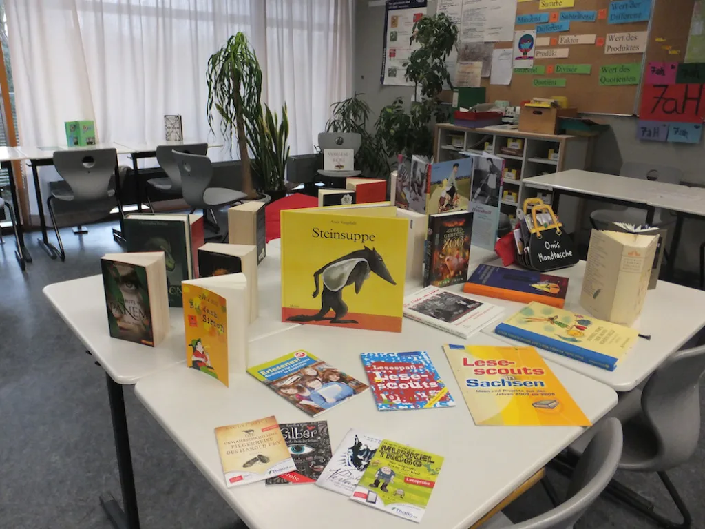 Tisch mit ausgelegten Büchern und Lesematerial im Klassenraum.